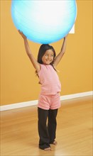 Hispanic girl lifting exercise ball