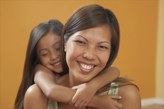 Pacific Islander mother and daughter hugging