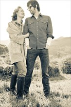 Couple standing in rural field