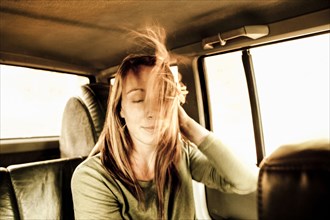 Caucasian woman's hair blowing in car