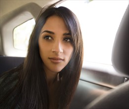 Woman sitting in back seat of car