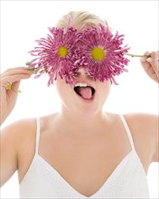 Portrait of silly woman covering eyes with flowers