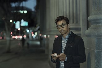 Man using cell phone on city street