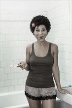 Woman brushing her teeth in bathroom