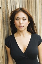Asian woman leaning against wall