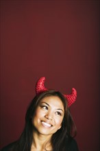 Asian woman wearing devil's horns