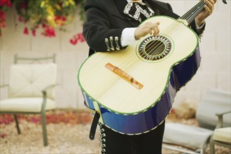 Mariachi band member holding guitar