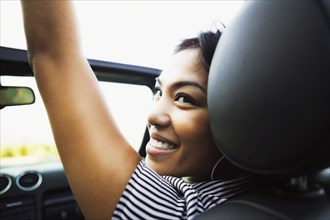 Asian woman in convertible car