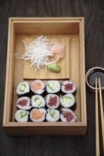 Box of sushi rolls and soy sauce
