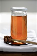 Honey in jar with dripper
