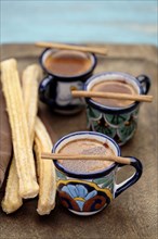 Mexican hot chocolate with cinnamon sticks and churros