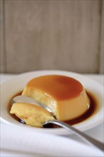 Flan on plate with spoon