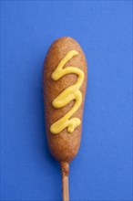 Close up of corn dog with mustard