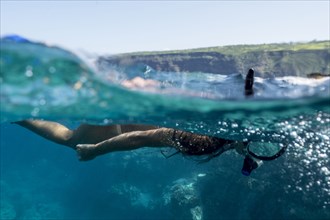 Mixed race woman snorkeling in tropical ocean