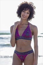 Mixed Race woman wearing bikini near ocean