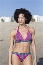 Mixed Race woman wearing bikini standing on beach