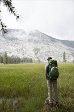 Caucasian man backpacking near mountain