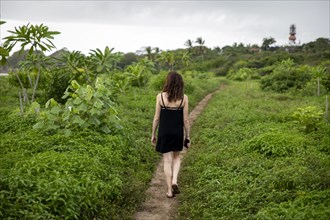 Woman walking on path through foliage