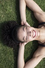 Mixed Race woman laying on grass relaxing