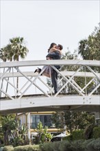 Kissing couple celebrating on bridge