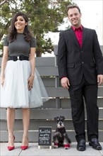 Couple with dog near wedding announcement