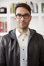 Portrait of smiling Caucasian man wearing jacket and eyeglasses