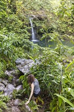 Woman hiking to remote waterfall