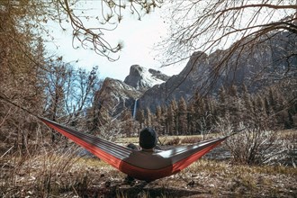 Caucasian man laying in hammock near mountains