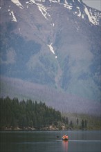 People kayaking in mountain lake