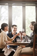 Friends drinking red wine together in restaurant