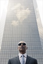 Black businessman standing near highrise