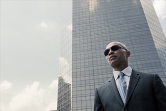 Black businessman standing near highrise