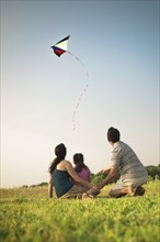 Family watching kite in sky