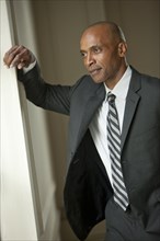 African American businessman leaning on wall