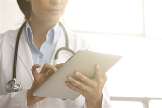 Hispanic doctor using digital tablet