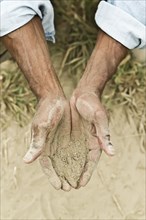 African American farmer checking dirt in field