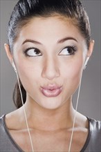 Surprised mixed race woman listening to headphones