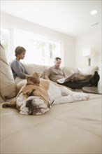 Couple relaxing on sofa with English bulldog