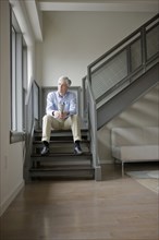 Caucasian man sitting in modern staircase