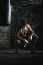 Caucasian boxer drinking water after training