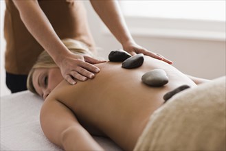 Caucasian woman receiving hot stone massage