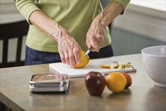 Senior woman cutting fruit