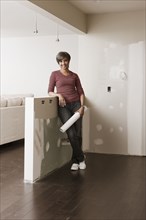 Mixed race woman standing in unfinished room with blueprints
