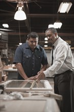 Businessman talking to worker in warehouse
