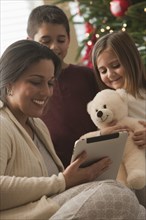 Family looking at digital tablet on Christmas morning