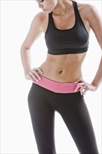 Caucasian woman in sportswear standing with hands on hips