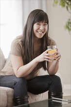 Asian woman drinking orange juice