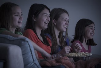 Friends eating popcorn and watching a movie