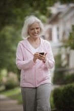Caucasian woman walking and listening to mp3 player