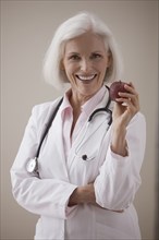 Caucasian doctor holding red apple